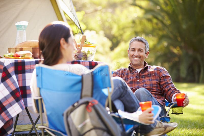 Couple Enjoying Camping Holiday In Countryside Smiling. Couple Enjoying Camping Holiday In Countryside Smiling