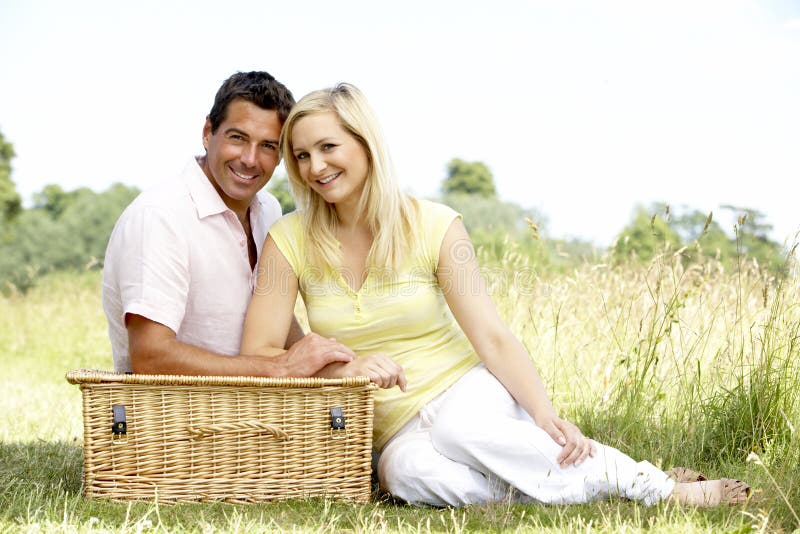 Young couple having picnic in countryside looking very relaxed. Young couple having picnic in countryside looking very relaxed