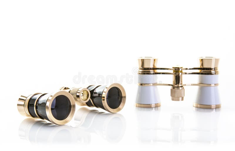 Two Pairs of opera glasses on a white background with reflection and copy space. Two Pairs of opera glasses on a white background with reflection and copy space