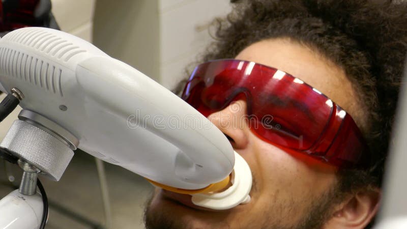 Пациент заканчивает забеливая обработку зубов