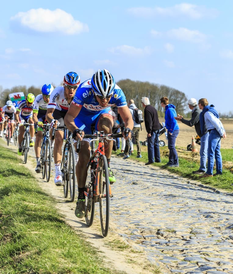 Carrefour de l'Arbre, France - April 12,2015: The peloton riding in the famous sector Careffour de l'Arbre during Paris-Roubaix race in 2015. Carrefour de l'Arbre, France - April 12,2015: The peloton riding in the famous sector Careffour de l'Arbre during Paris-Roubaix race in 2015