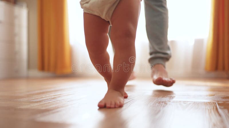 первые шаги. концепция 'счастливая семья - ребенок мечты'. отец учит дочку делать первые шаги дома в акции видеоматериалы