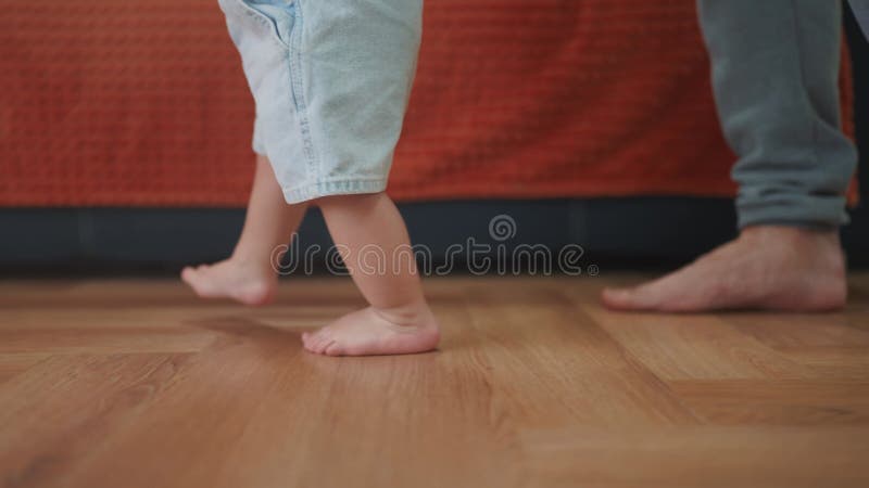 первые шаги. Папочка учит малыша-малыша делать первые шаги. счастливая семейная мечта. ребенок в помещении сток-видео