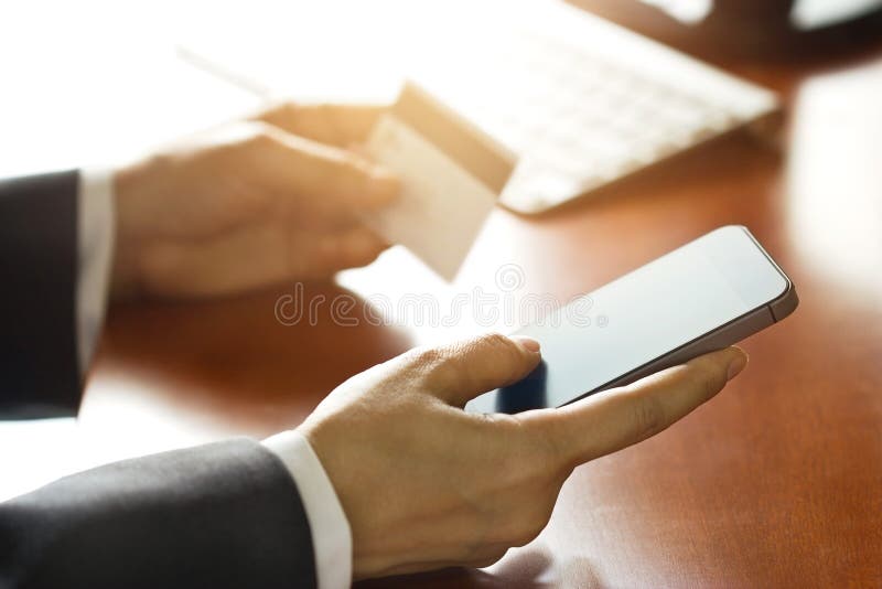 Передвижные оплаты, бизнесмен используя smartphone и кредитную карточку для онлайн покупок стоковое фото rf Передвижные оплаты, бизнесмен используя smartphone и кредитную карточку для онлайн покупок стоковое фото rf