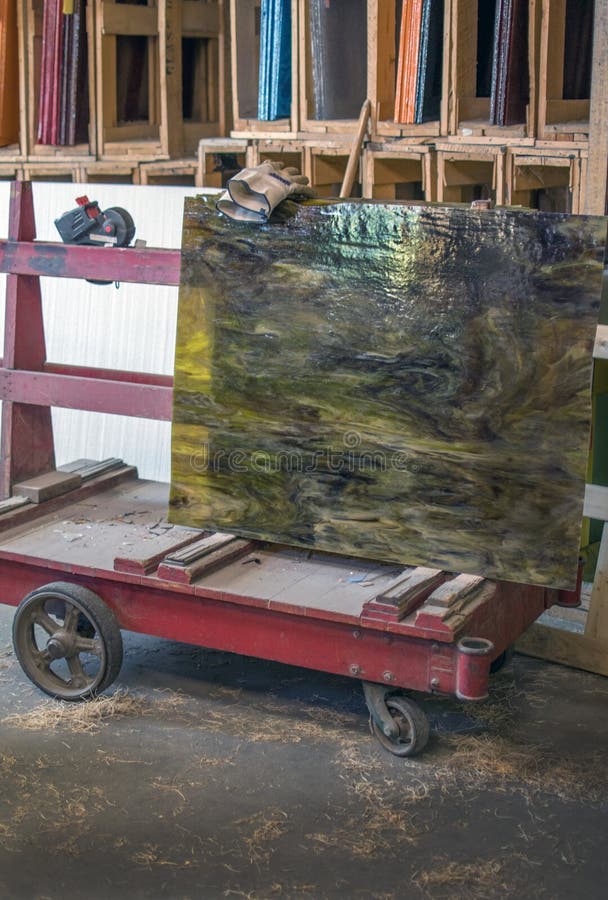 A metal cart with special sides and grooves help hold sheets of stained glass, so they may be moved to other areas or wheeled out to purchase and take home. A metal cart with special sides and grooves help hold sheets of stained glass, so they may be moved to other areas or wheeled out to purchase and take home