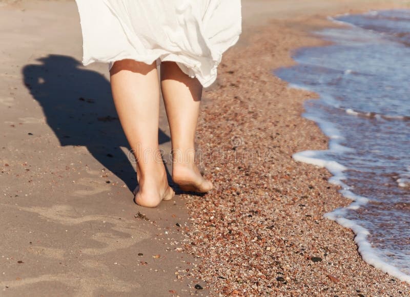 vacation travel - woman leg closeup walking on white sand relaxing in beach cover-up pareo beachwear. and tanned legs. Sunmmer holidays, weight loss or epilation, pedicure concept. vacation travel - woman leg closeup walking on white sand relaxing in beach cover-up pareo beachwear. and tanned legs. Sunmmer holidays, weight loss or epilation, pedicure concept.