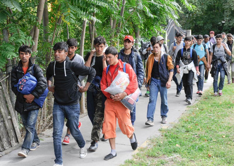 NOVA PAZOVA, SERBIA - CIRCA OCTOBER 2016: Migrants from middle east walks to Hungarian border, circa October 2016 in Nova Pazova. NOVA PAZOVA, SERBIA - CIRCA OCTOBER 2016: Migrants from middle east walks to Hungarian border, circa October 2016 in Nova Pazova