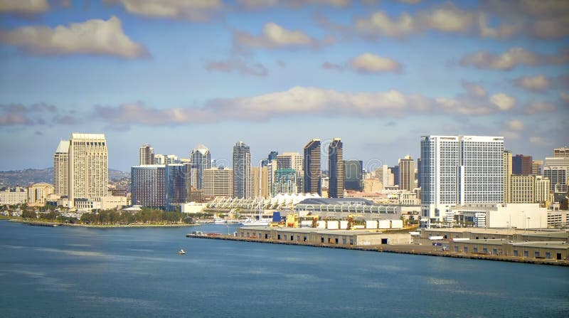 The downtown skyline of San Diego from the Coronado Bridge, crossing San Diego Bay, including the landmark convention center, on a bright blue sky, blue water day. The downtown skyline of San Diego from the Coronado Bridge, crossing San Diego Bay, including the landmark convention center, on a bright blue sky, blue water day.