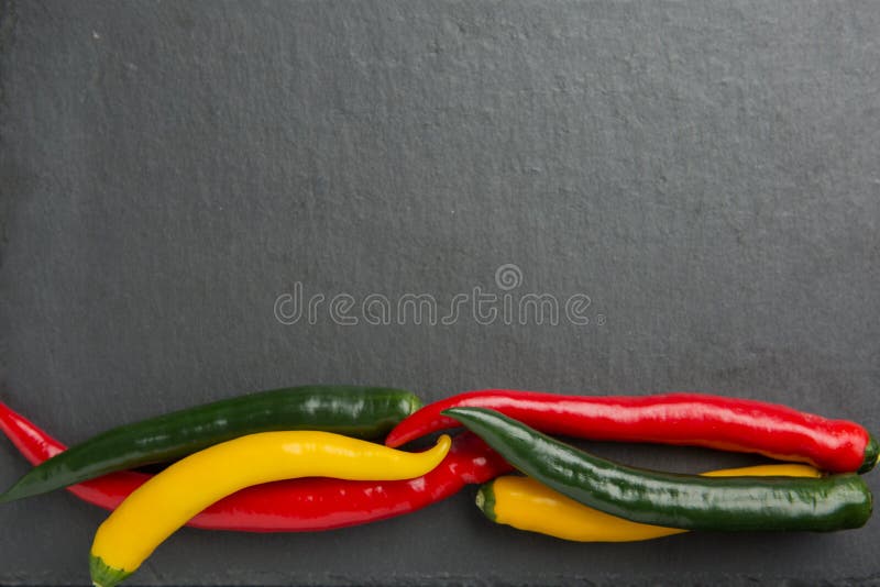 3 перца chili colorsr на темном шифере облицовывают сляб стоковые фото 3 перца chili colorsr на темном шифере облицовывают сляб стоковые фото