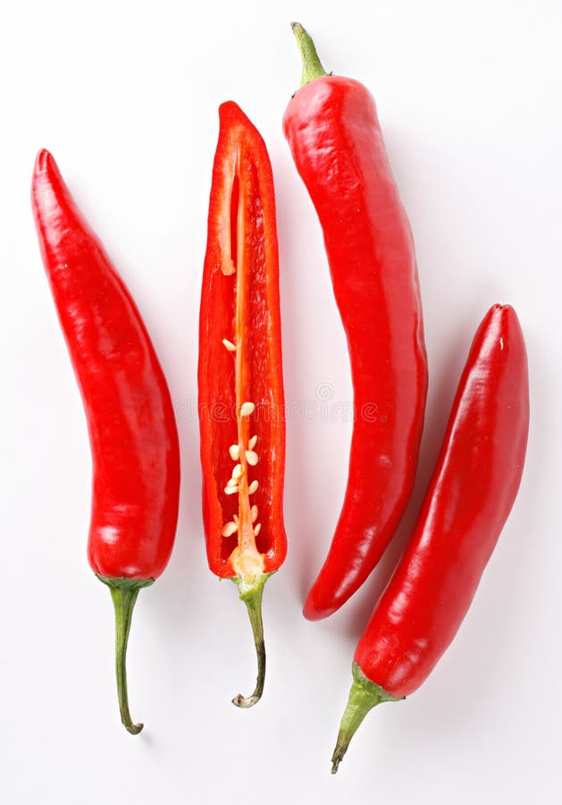 A composition of four chili peppers on a white background. One of the peppers is cut lengthwise showing seeds and internal texture. A composition of four chili peppers on a white background. One of the peppers is cut lengthwise showing seeds and internal texture.