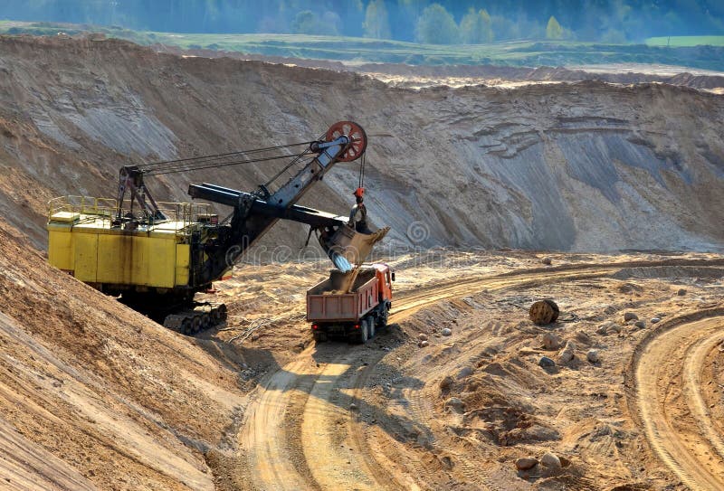 Песок загрузки экскаватора карьера или в самосвал на opencast стоковые изображения Песок загрузки экскаватора карьера или в самосвал на opencast стоковые изображения