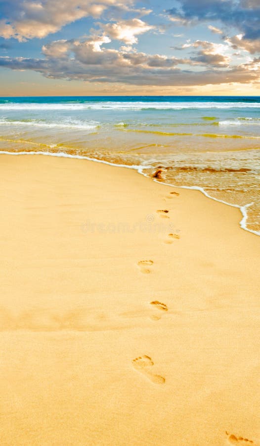 Footprints in the yellow sand, sea in distance. Footprints in the yellow sand, sea in distance.