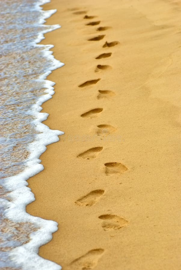 Ocean wave wash away human footprints on sand at the beach. Ocean wave wash away human footprints on sand at the beach