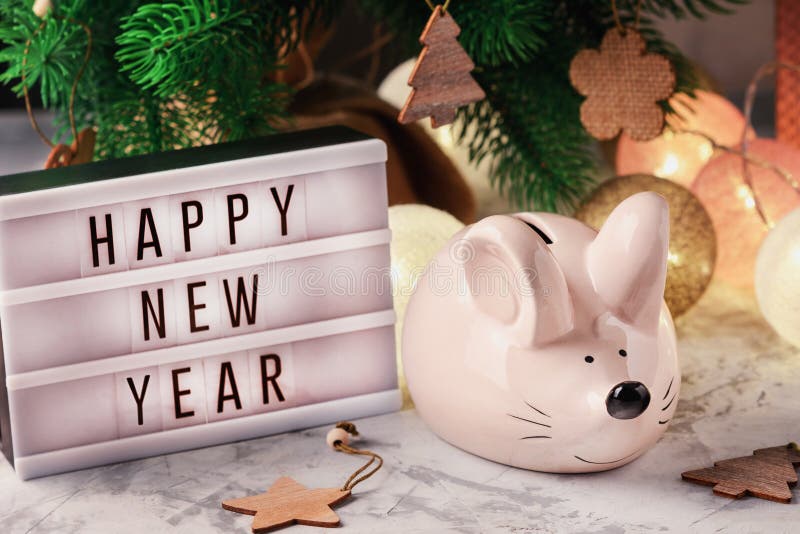 Пигги-банк в виде мыши Lightbox с новогодней надписью Happy Рождественские украшения, гарланд и шарики стоковые фотографии rf