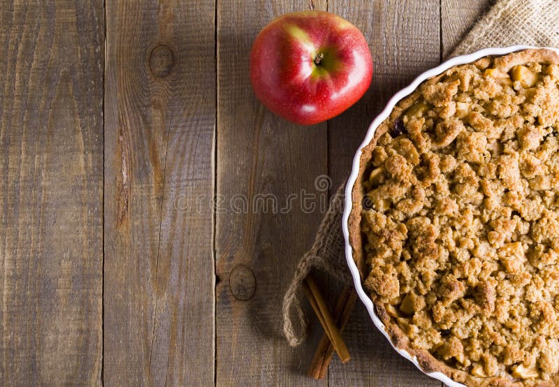 Пирог с крошит на предпосылке планки Crumble Яблока Яблочный пирог с крошит на деревянной предпосылке стоковая фотография rf