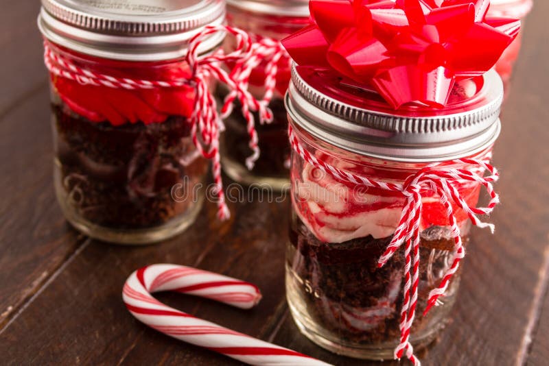 Chocolate peppermint cupcakes in a jar with red and white bakers twine, red bows and candy cane. Chocolate peppermint cupcakes in a jar with red and white bakers twine, red bows and candy cane