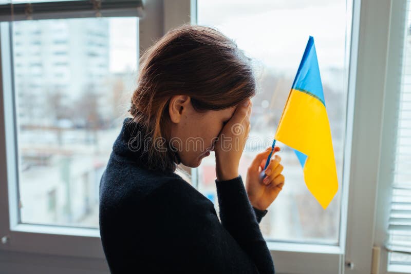 плачущая женщина, держащая украинский флаг во время войны с русской. вторжение в украину 2022 года стоковое изображение