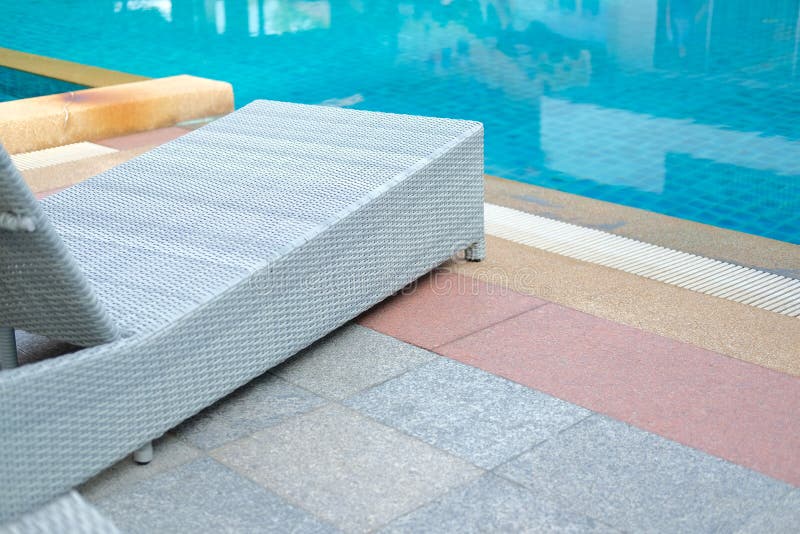 Плетеное deckchair шезлонга бассейна ротанга на бассейне стоковая фотография Плетеное deckchair шезлонга бассейна ротанга на бассейне стоковая фотография