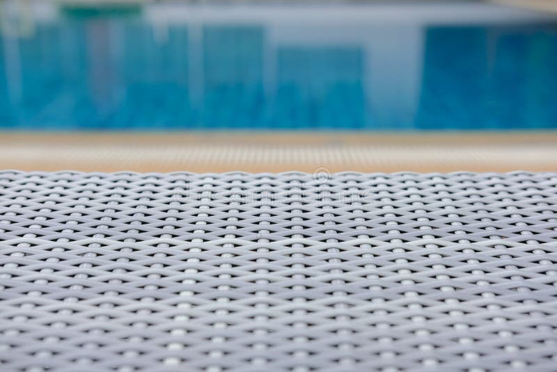 Плетеное deckchair шезлонга бассейна ротанга на бассейне стоковая фотография rf Плетеное deckchair шезлонга бассейна ротанга на бассейне стоковая фотография rf