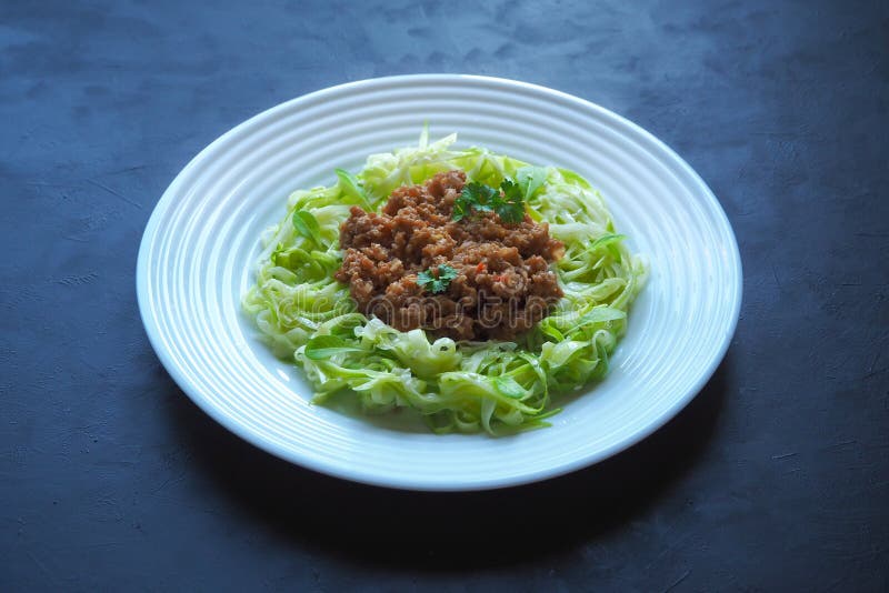 Плита спагетти цукини с говядиной bolognese на черной предпосылке стоковые изображения rf Плита спагетти цукини с говядиной bolognese на черной предпосылке стоковые изображения rf