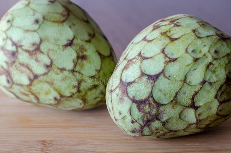 Плод Cherimoya на предпосылке деревянного стола 2 cherimoyas clos стоковое фото rf Плод Cherimoya на предпосылке деревянного стола 2 cherimoyas clos стоковое фото rf