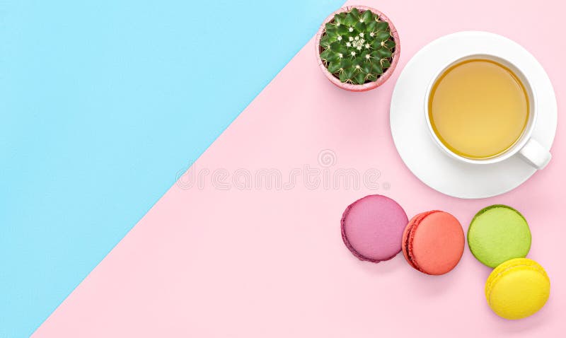 Плоское фото положения стола офиса с кружкой чая, кактусом, macaroons розовыми и голубой предпосылкой стоковые фото Плоское фото положения стола офиса с кружкой чая, кактусом, macaroons розовыми и голубой предпосылкой стоковые фото