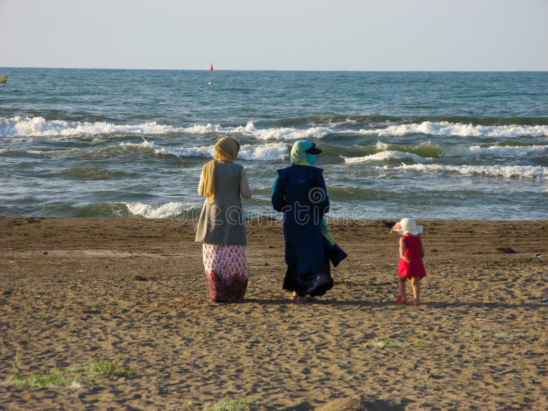 Пляж мусульманского hijab женщин идя Мусульманские женщины в hijab идя на пляж Каспийского моря в Иране, Anzali стоковое изображение Пляж мусульманского hijab женщин идя Мусульманские женщины в hijab идя на пляж Каспийского моря в Иране, Anzali стоковое изображение