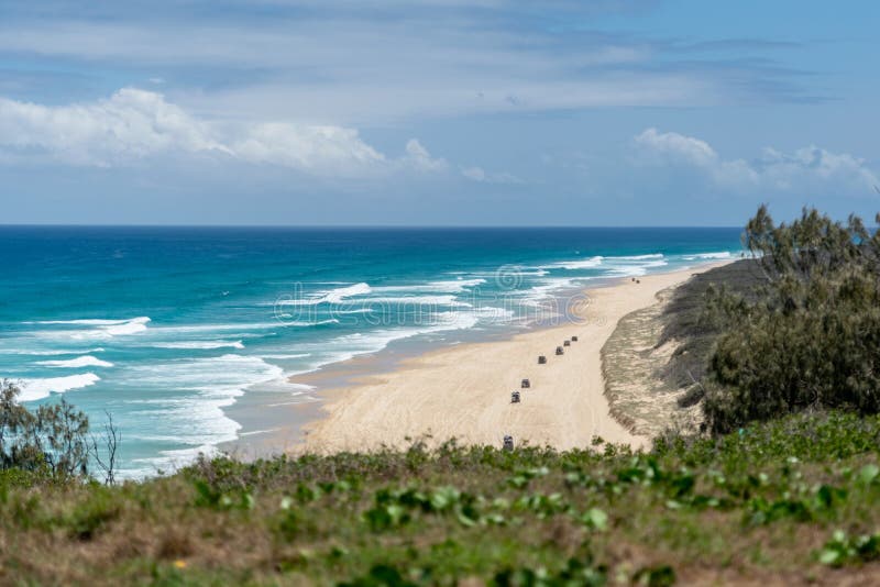 75 Mile Beach on Fraser Island, Queensland, Australia, seen from Indian Head headland which marks both the most easterly point on the island and the northern end of the beach. 4WD cars in background. 75 Mile Beach on Fraser Island, Queensland, Australia, seen from Indian Head headland which marks both the most easterly point on the island and the northern end of the beach. 4WD cars in background.