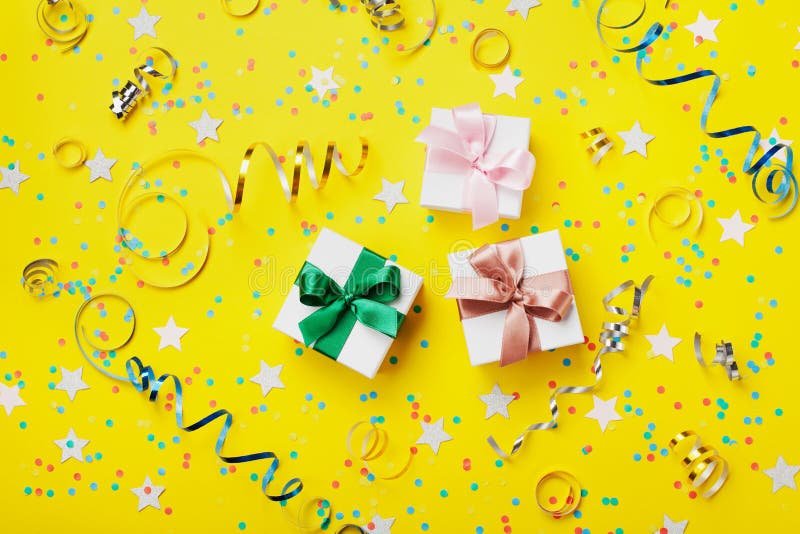 Подарок или присутствующая коробка украсили красочные confetti, звезду, конфету и ленту на желтом взгляде столешницы плоский стил стоковые изображения rf Подарок или присутствующая коробка украсили красочные confetti, звезду, конфету и ленту на желтом взгляде столешницы плоский стил стоковые изображения rf