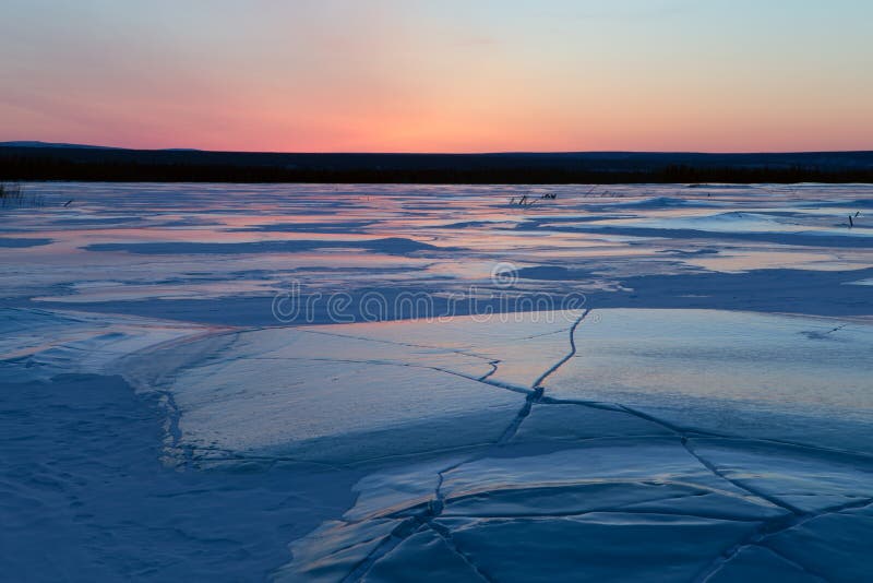 Ice field in cracks and red sky. Indigirka. Yakutia. Russia. Ice field in cracks and red sky. Indigirka. Yakutia. Russia.