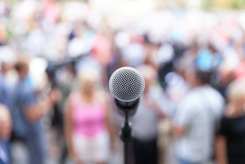 Microphone in focus against blurred audience. Microphone in focus against blurred audience