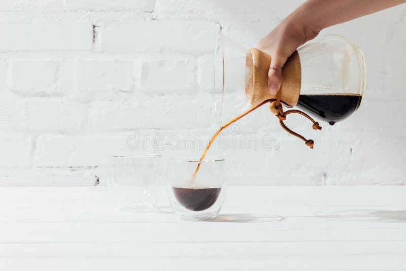 Подрезанная съемка женщины лить альтернативный кофе от chemex в стеклянную кружку стоковые фото Подрезанная съемка женщины лить альтернативный кофе от chemex в стеклянную кружку стоковые фото