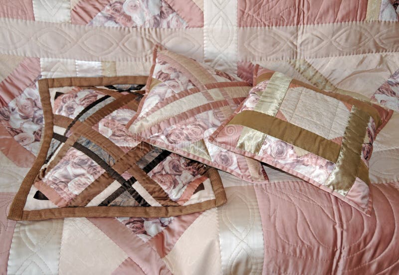 Three quilted pillows on the patchwork cover. Three quilted pillows on the patchwork cover