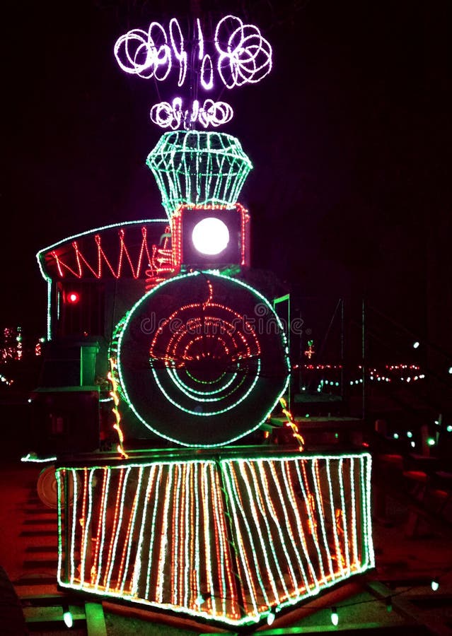 Christmas train lined with brightly colored lights against black night background. Christmas train lined with brightly colored lights against black night background.