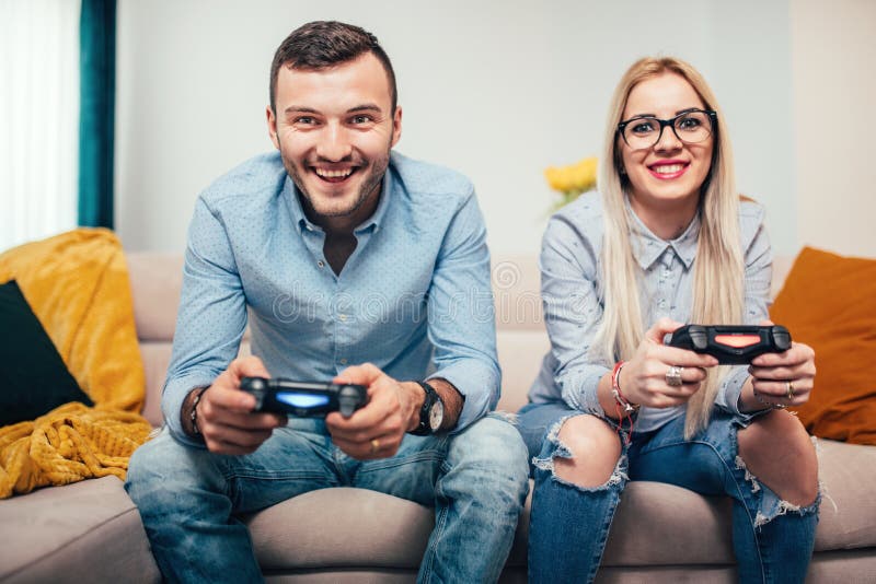 Пожененные пары играя видеоигры на общей консоли игры Детали современного образа жизни при пары имея потеху стоковые изображения Пожененные пары играя видеоигры на общей консоли игры Детали современного образа жизни при пары имея потеху стоковые изображения