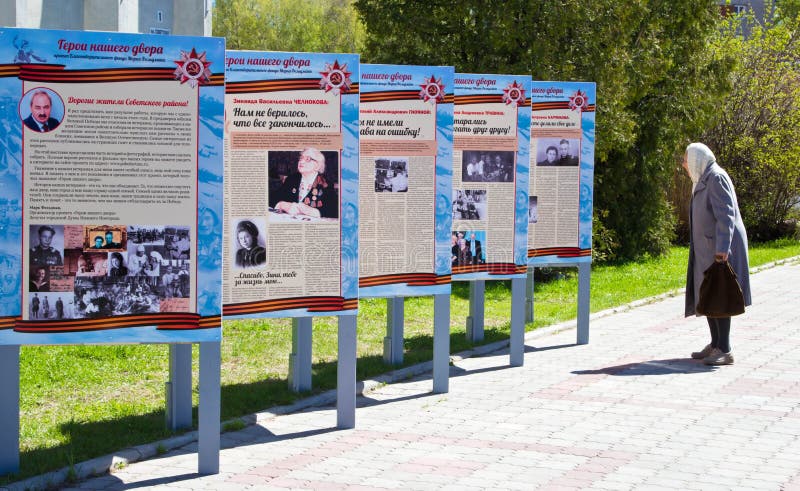 Пожилой текст чтения женщины и наблюдая изображения на стойке стоковые изображения rf Пожилой текст чтения женщины и наблюдая изображения на стойке стоковые изображения rf
