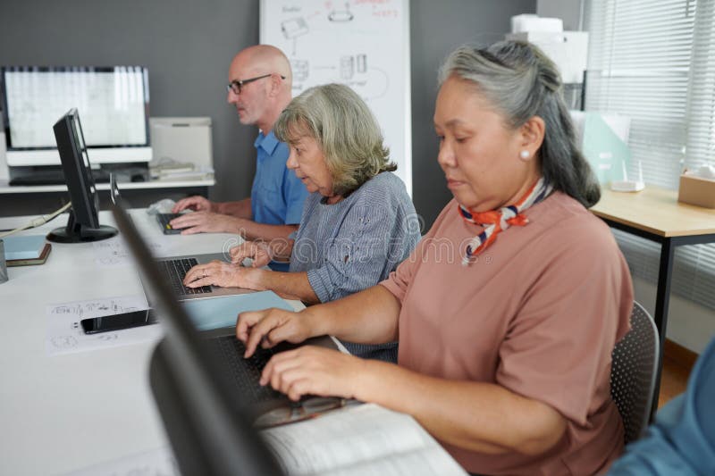 Group of senior people attending computer class to learn how to use internet, send e-mails and videocall. Group of senior people attending computer class to learn how to use internet, send e-mails and videocall