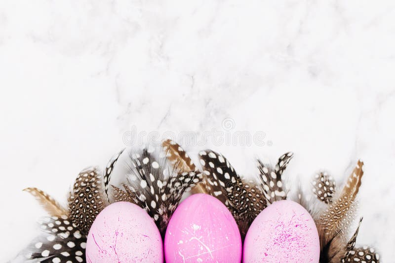 Покрашенный пинк пасхи eggs с стильными пер на мраморной предпосылке предпосылка красит желтый цвет праздника красный стоковое фото Покрашенный пинк пасхи eggs с стильными пер на мраморной предпосылке предпосылка красит желтый цвет праздника красный стоковое фото