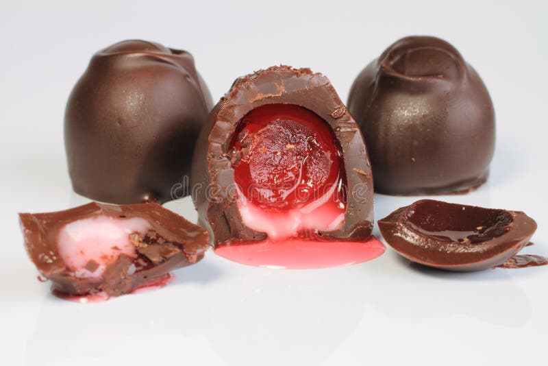 A close up image of a chocolate covered cherry that is cut in half. A close up image of a chocolate covered cherry that is cut in half.