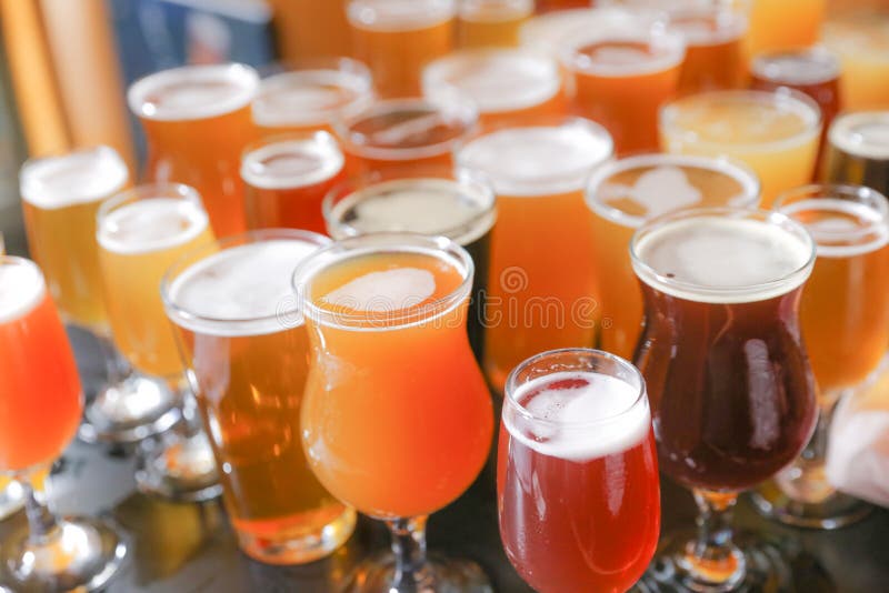 A Craft Beer Tasting Flight Sample of Many Beers Are On Display on a Bar Counter. A Craft Beer Tasting Flight Sample of Many Beers Are On Display on a Bar Counter