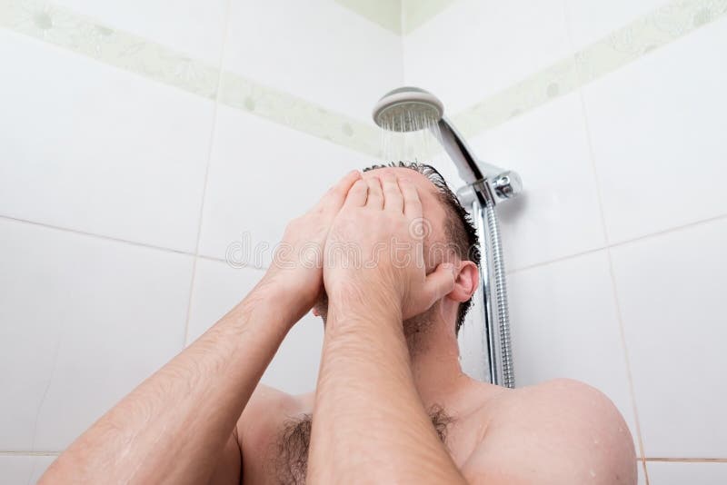 Man taking a shower washing hair under water falling from rain showerhead. Showering person at home. Young adult body care morning routine. Man taking a shower washing hair under water falling from rain showerhead. Showering person at home. Young adult body care morning routine.