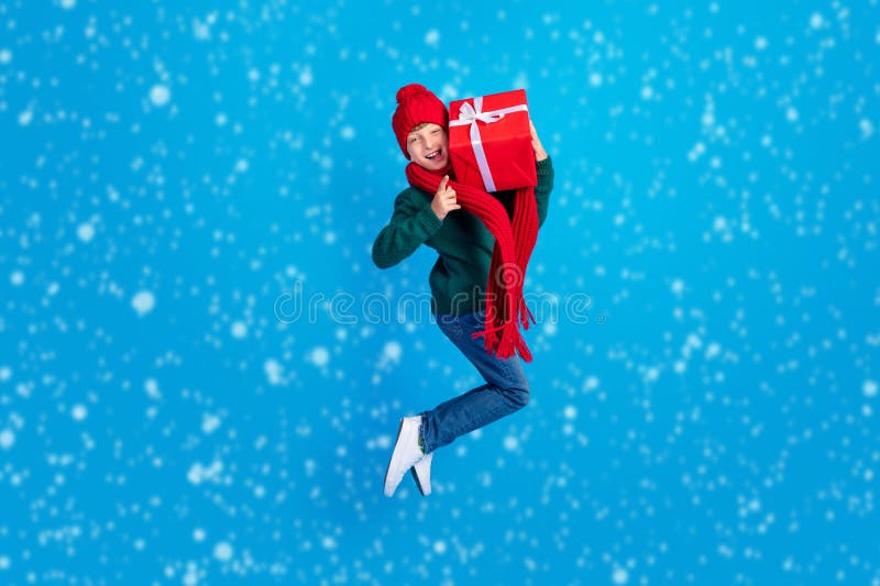 полноразмерный размер тела фото мальчик прыгать сохраняя xmas настоящее показывая рога изолированный ярко-синий цвет фона стоковая фотография