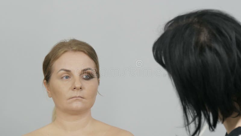 Половина макияжных глаз в особенном профессиональном макияже с дымящимся глазом. художник-макияж со специальными кистями и космети сток-видео