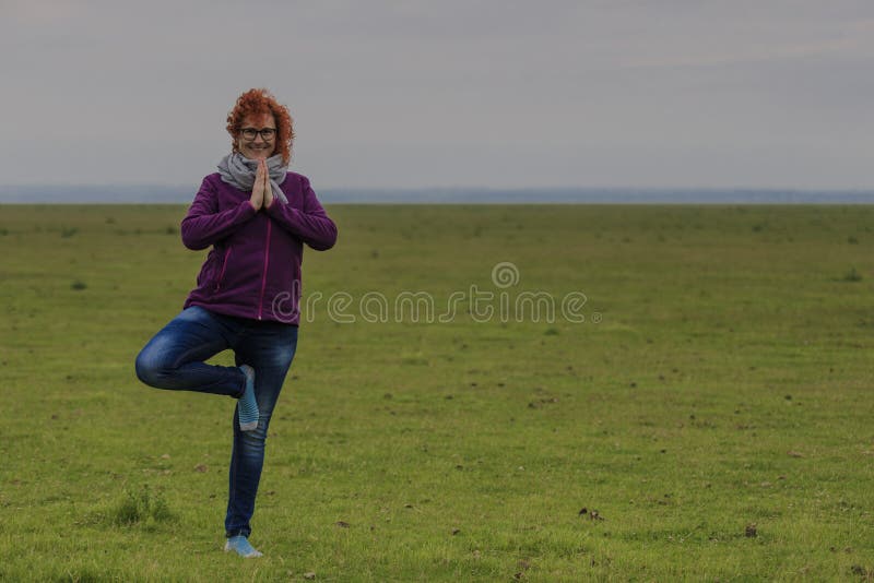 Положение дерева йоги женщины Redhead практикуя стоковая фотография Положение дерева йоги женщины Redhead практикуя стоковая фотография