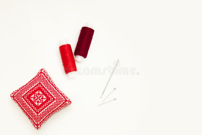 Положение квартиры с handmade красной вышитой пусковой площадкой иглы, катышками потока, штырями, иглами, насмешливыми вверх, взг стоковая фотография Положение квартиры с handmade красной вышитой пусковой площадкой иглы, катышками потока, штырями, иглами, насмешливыми вверх, взг стоковая фотография