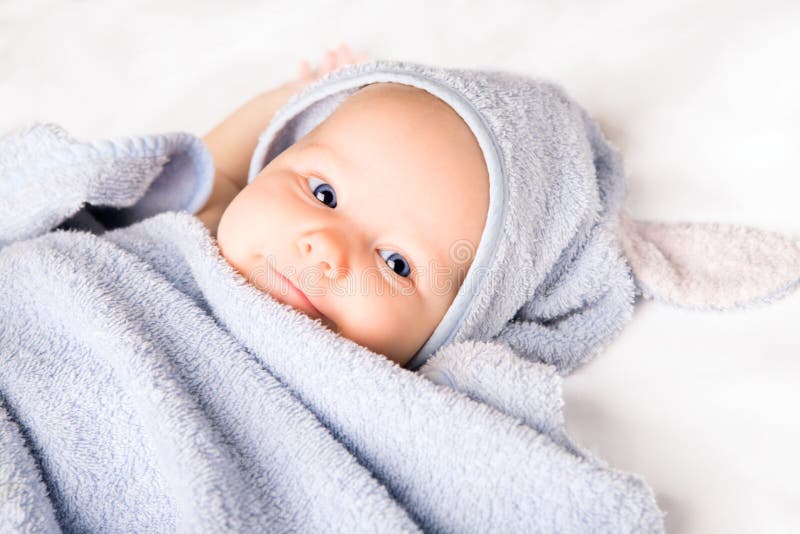 Cute baby girl with towel after bath on white blanket. Cute baby girl with towel after bath on white blanket