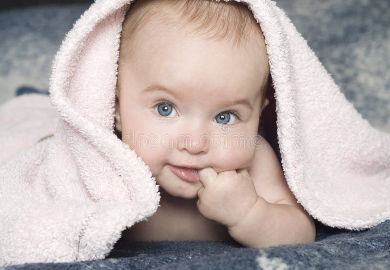 Cute smiling baby girl with a pink towel. Cute smiling baby girl with a pink towel.