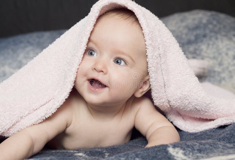 Cute smiling baby girl with a pink towel. Cute smiling baby girl with a pink towel.
