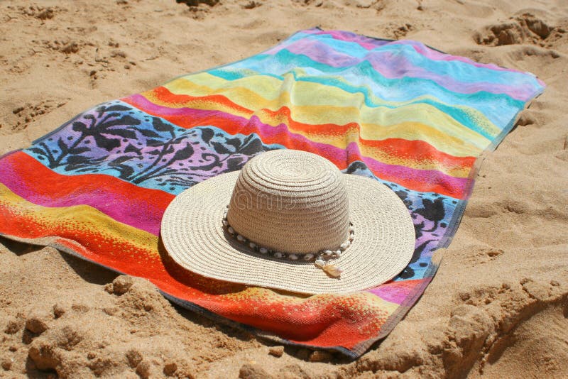 Beach hat and towel in the sand. Beach hat and towel in the sand