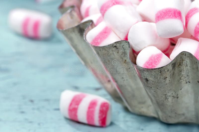 Peppermint sweets in a rustic cupcake bowl with shabby chic wooden background. Peppermint sweets in a rustic cupcake bowl with shabby chic wooden background